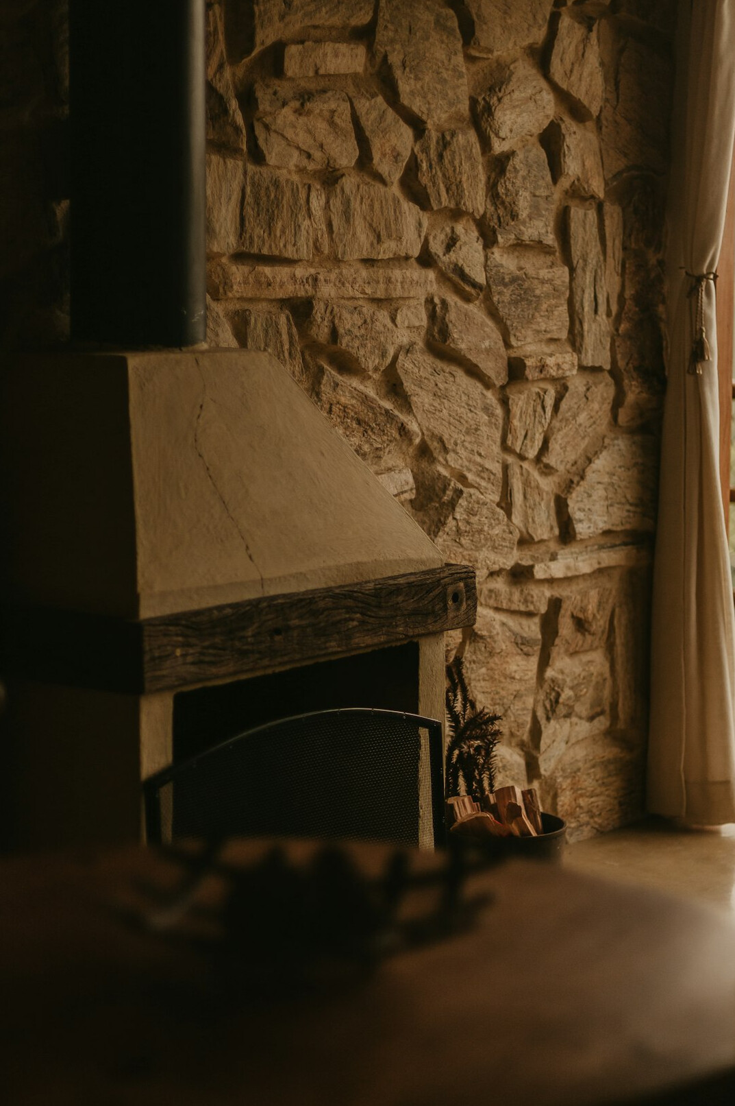 Intérieur de chalet alpin avec poutres en bois et cheminée en pierre